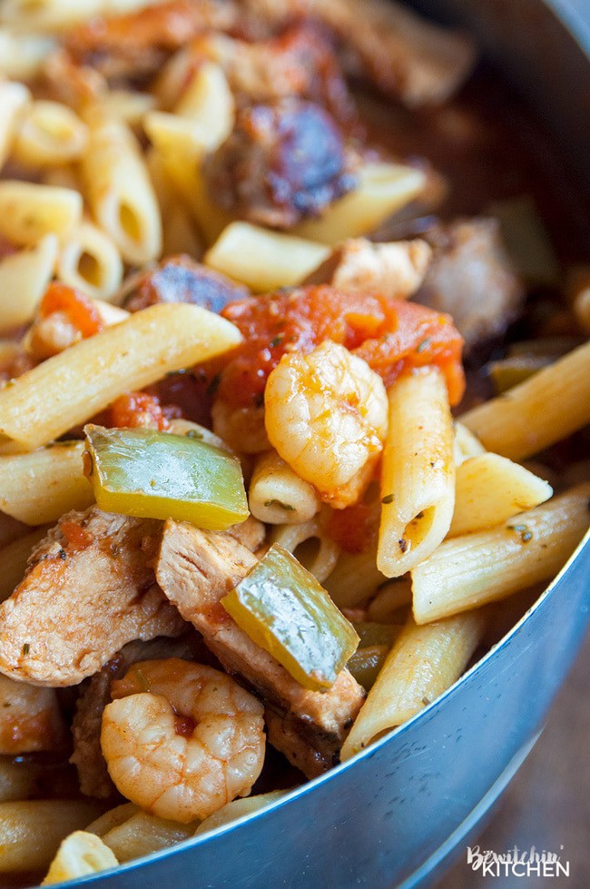 A pan with noodles, shrimp, tomatoes, peppers, and other jambalaya fixins.