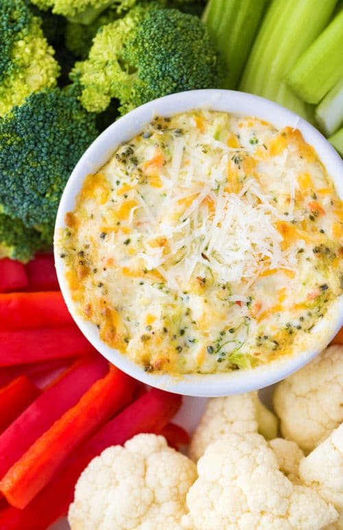 A vegetable tray with a cheesy hot broccoli dip in the center.