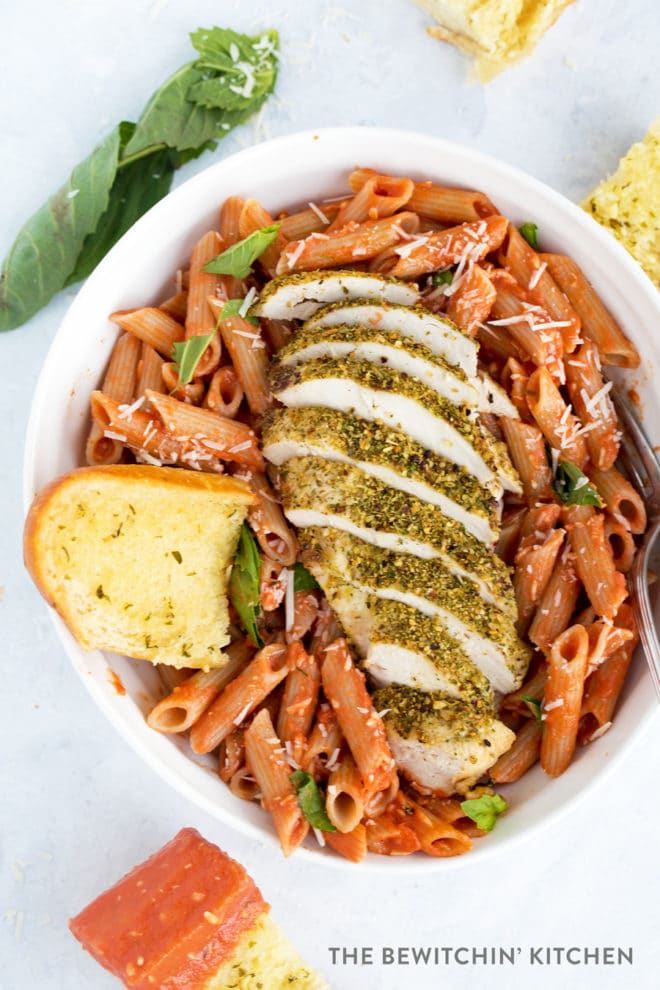 Sliced chicken breast crusted in herbs over penne pasta and sauce.