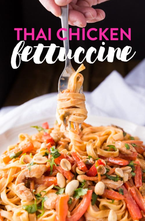 A fork twisting fettuccine noodles in a homemade thai peanut sauce.