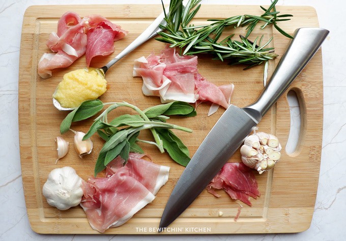 prosciutto, rosemary, and sage on a cutting board