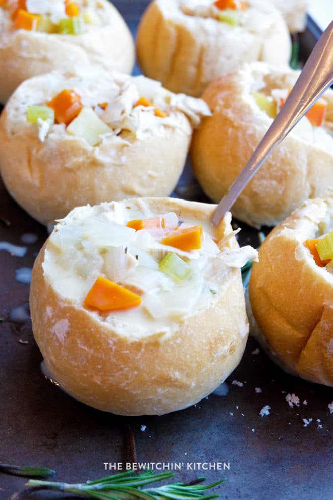 homemade turkey soup in a bread bowl with carrots and celery