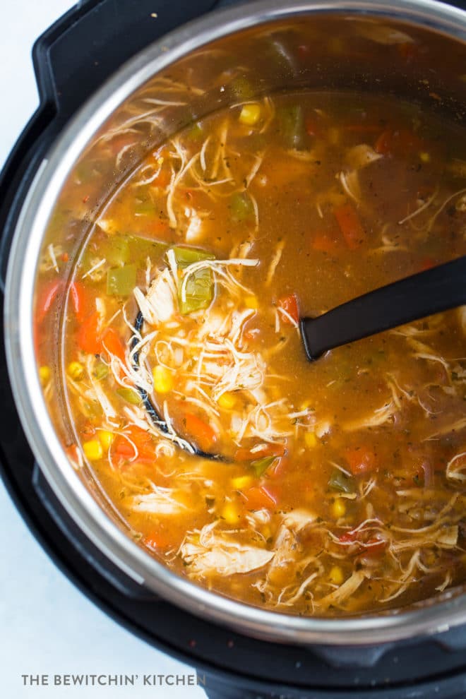 A ladle lifting chicken tortilla soup out of an instant pot.