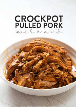 Pulled pork made in a slow cooker in a bowl with a white background