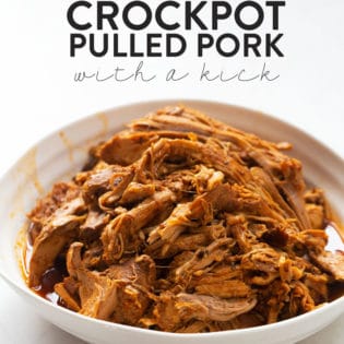 Pulled pork made in a slow cooker in a bowl with a white background
