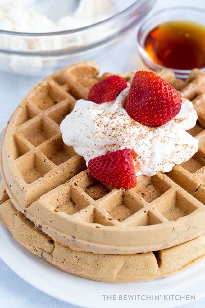 Cinnamon Zucchini Waffles topped with whipped cream and fruit