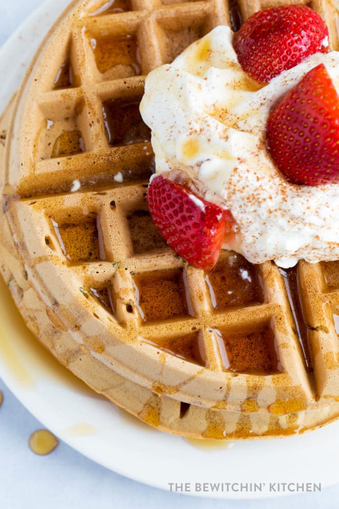 Overhead shot of crispy waffles with maple syrup drizzled on top and down the side