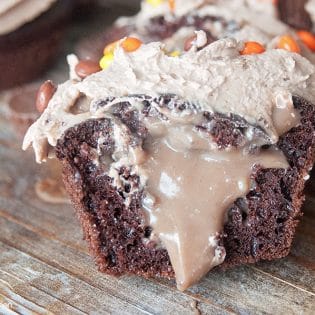 The PMS Buster - Chocolate Peanut Butter Filled Cupcakes with the world's best buttercream recipe: Chocolate Peanut Butter Frosting. Must try dessert recipe!