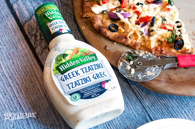 Greek Pizza - pizza crust topped with tangy greek vinaigrette, chicken, red pepper, spinach, olives , purple onion, feta and mozzarella. Finished with a greek tzatziki drizzle. So much yum happening right here. | thebewitchinkitchen.com