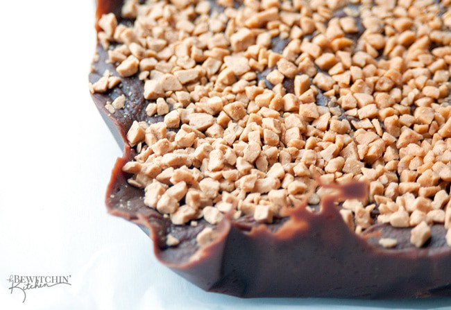 3 minute Chocolate Peanut Butter Fudge with a Crunchy Toffee Topping - this no bake dessert couldn't get any easier! Toss it in the microwave, top with Skor pieces, freeze and you're done! | thebewitchinkitchen.com