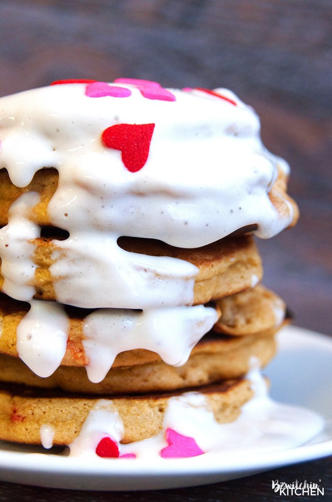 Gluten free pancakes smothered in a strawberry greek yogurt cream cheese sauce. This gluten free pancake recipe is so fluffy and yummy! A healthy breakfast packed with flavor. | thebewitchinkitchen.com