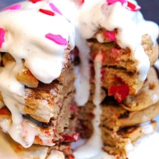 Gluten free pancakes smothered in a strawberry greek yogurt cream cheese sauce. This gluten free pancake recipe is so fluffy and yummy! A healthy breakfast packed with flavor. | thebewitchinkitchen.com