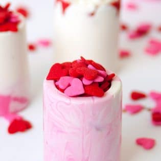 Easy Valentine's Day dessert idea: vanilla chocolate shot glasses. This no bake dessert uses Candy Melts and a shot glass mold. Perfect for kid's Valentine's parties. |thebewitchinkitchen.com