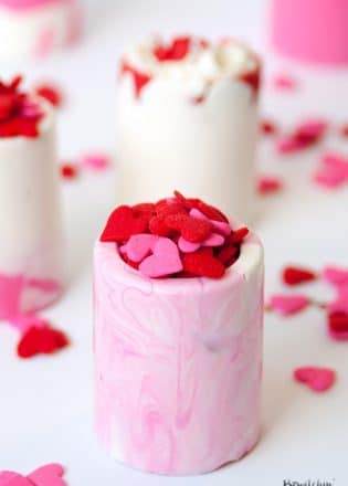 Easy Valentine's Day dessert idea: vanilla chocolate shot glasses. This no bake dessert uses Candy Melts and a shot glass mold. Perfect for kid's Valentine's parties. |thebewitchinkitchen.com