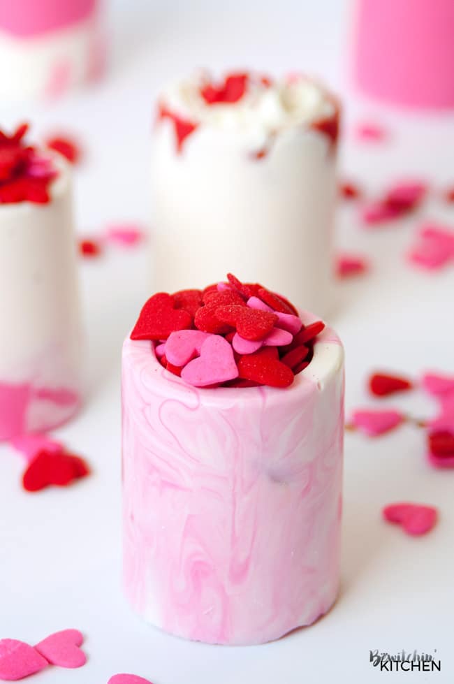 Easy Valentine's Day dessert idea: vanilla chocolate shot glasses. This no bake dessert uses Candy Melts and a shot glass mold. Perfect for kid's Valentine's parties. |thebewitchinkitchen.com