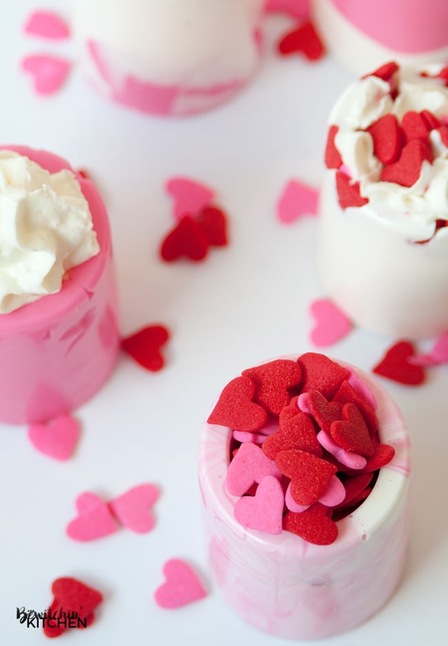 Easy Valentine's Day dessert idea: vanilla chocolate shot glasses. This no bake dessert uses Candy Melts and a shot glass mold. Perfect for kid's Valentine's parties. |thebewitchinkitchen.com
