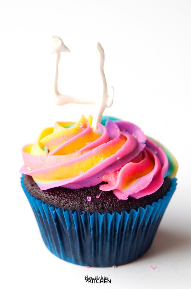 chocolate cupcake topped with rainbow swirl buttercream and a number 4