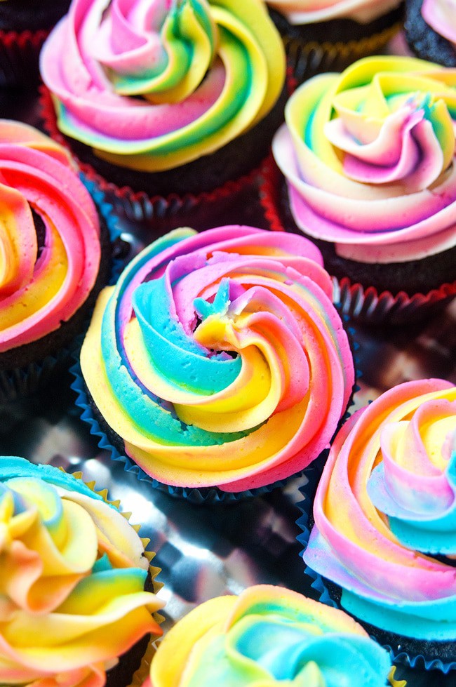 closeup of chocolate cupcakes topped with rainbow swirl frosting