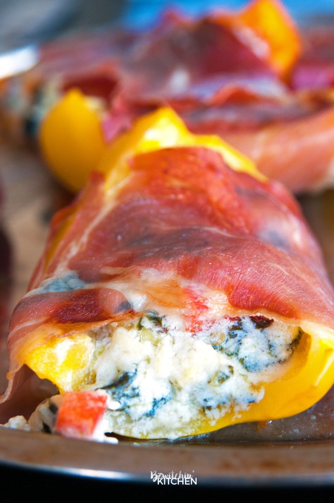 Spinach artichoke stuffed peppers wrapped in prosciutto. Add this to your appetizer recipes. Spinach dip, bell peppers, prosciutto - it sounds like heaven. It has a little kick from jalapenos too. The perfect party food recipe. | thebewitchinkitchen.com
