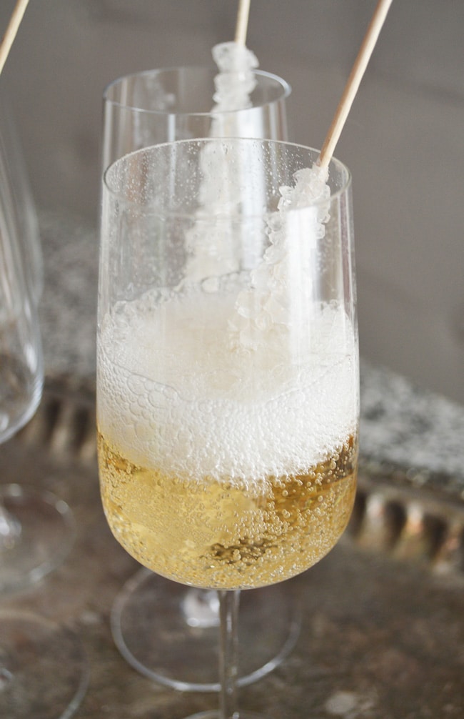 This champagne on the rocks idea is an elegant way to glam up your party (or Friday night). Perfect New Years Eve Party Idea. It's so easy too: sparkling wine and rock candy! An easy and low cost way to add class to your party.