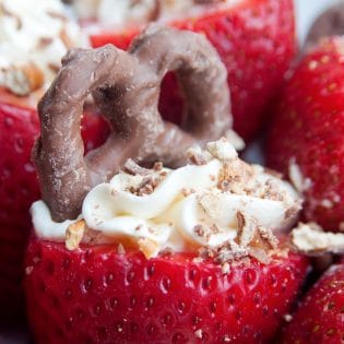 Cheesecake Stuffed Strawberries. This easy, no bake dessert recipe is a party favorite. Cream cheese, sugar and vanilla, topped with crunchy milk chocolate covered pretzels makes this bite sized treat sweet, salty and crunchy. Add this to your popular desserts board.