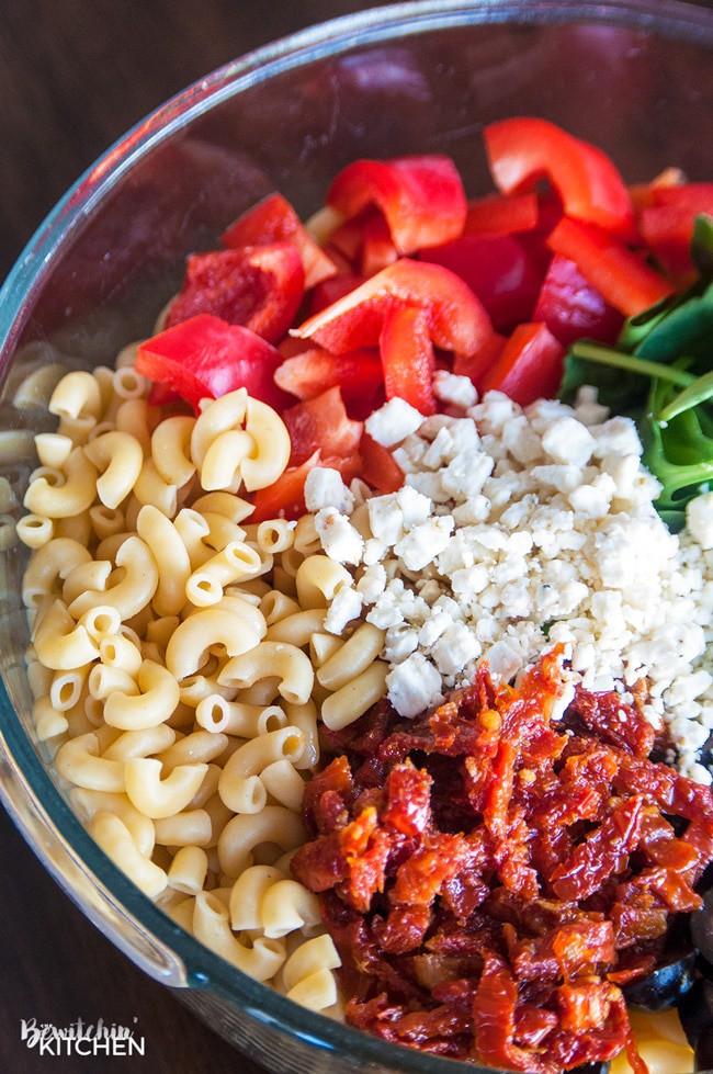 Pesto Pasta Salad - this tangy twist on a macaroni salad is my new favorite summer salad recipe. Sundried tomatoes, smart veggie pasta, spinach, feta cheese, red pepper, and olives tossed in a homemade honey pesto vinaigrette. Also makes a delicious and nutritious addition to a school lunch.