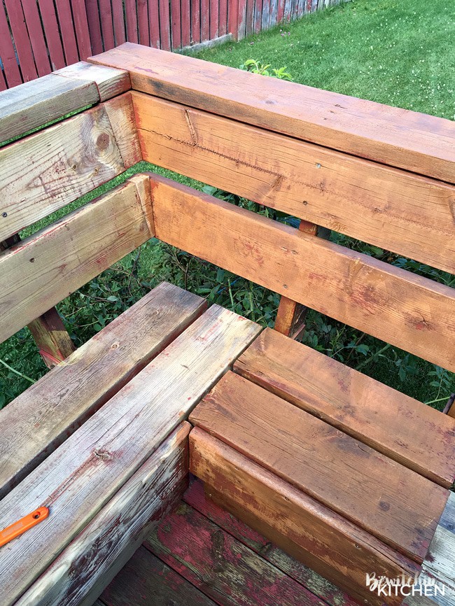 How to stain a deck in 4 easy steps. This DIY deck renovation uses Behr's Premium Deck Stripper, Wood Cleaner and Semi-Transparent Stain in Redwood Naturaltone. The before and after looks incredible!