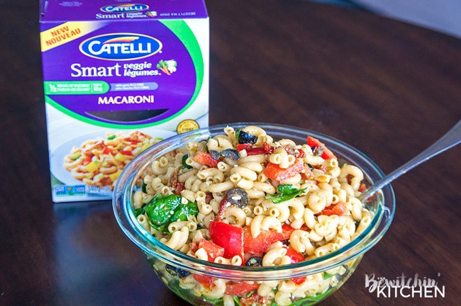 Pesto Pasta Salad - this tangy twist on a macaroni salad is my new favorite summer salad recipe. Sundried tomatoes, smart veggie pasta, spinach, feta cheese, red pepper, and olives tossed in a homemade honey pesto vinaigrette. Also makes a delicious and nutritious addition to a school lunch.