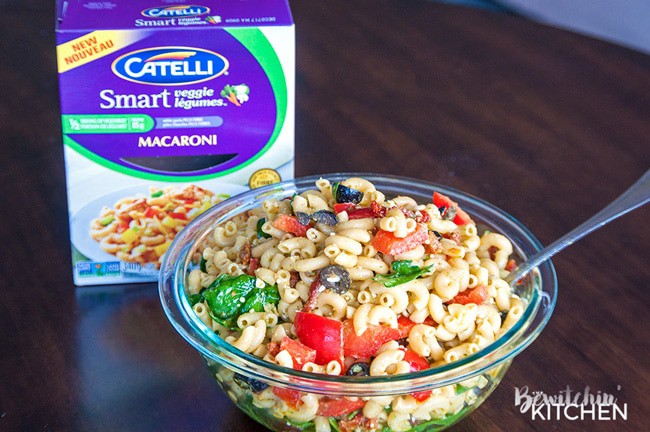 Pesto Pasta Salad - this tangy twist on a macaroni salad is my new favorite summer salad recipe. Sundried tomatoes, smart veggie pasta, spinach, feta cheese, red pepper, and olives tossed in a homemade honey pesto vinaigrette. Also makes a delicious and nutritious addition to a school lunch.