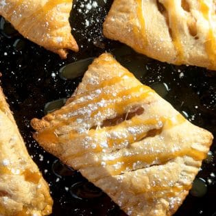 apple turnovers with powdered sugar and caramel drizzle