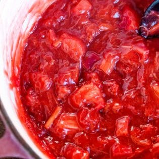 stirring a pot of strawberry rhubarb pie filling