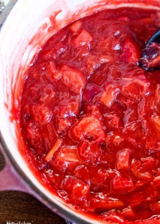 stirring a pot of strawberry rhubarb pie filling