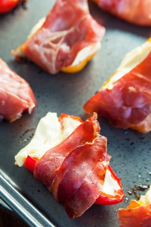 Prosciutto Wrapped Stuffed Peppers Recipe - these easy stuffed peppers are loaded with cream cheese and wrapped with salt prosciutto (fancy bacon). Perfect appetizer for parties and the holidays (like Christmas, Thanksgiving and New Years).