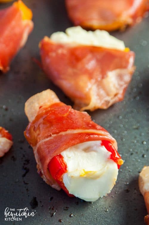 Prosciutto Wrapped Stuffed Peppers Recipe - these easy stuffed peppers are loaded with cream cheese and wrapped with salt prosciutto (fancy bacon). Perfect appetizer for parties and the holidays (like Christmas, Thanksgiving and New Years).