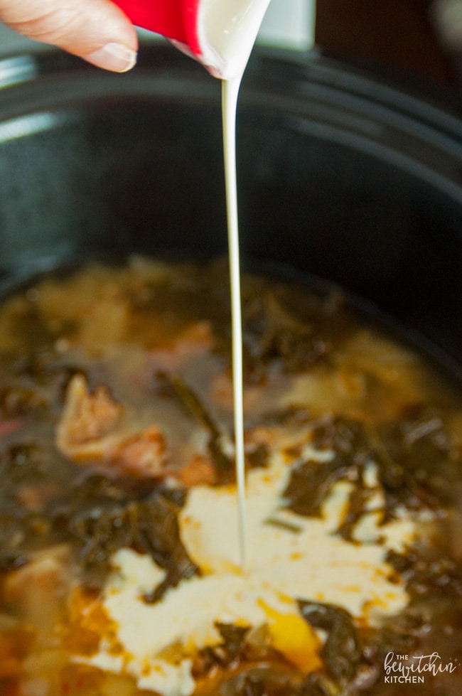 closeup: pouring cream into a crockpot full of slow cooker zuppa toscana