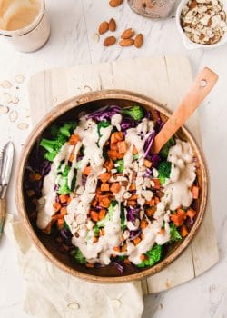 This paleo winter bowl recipe has roasted sweet potato, broccoli, finely shredded red cabbage, pulled together with a creamy vegan almond and honey dressing. Serve as a side dish or add some chicken or tofu for a healthy lunch or dinner.