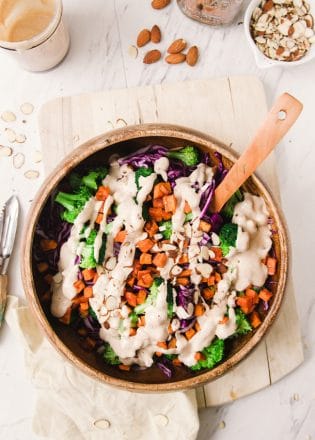 This paleo winter bowl recipe has roasted sweet potato, broccoli, finely shredded red cabbage, pulled together with a creamy vegan almond and honey dressing. Serve as a side dish or add some chicken or tofu for a healthy lunch or dinner.