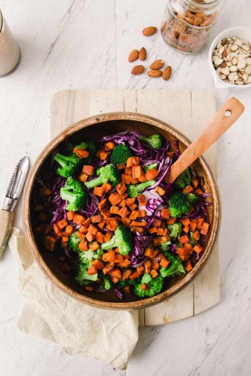 This paleo winter bowl recipe has roasted sweet potato, broccoli, finely shredded red cabbage, pulled together with a creamy vegan almond and honey dressing. Serve as a side dish or add some chicken or tofu for a healthy lunch or dinner.