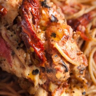 Sundried tomato stuffed chicken breasts with a creamy tomato parmesan sauce. This chicken breast recipe is stuffed with sundried tomatoes, cream cheese, and artichokes. Delicious served over pasta or with a healthy side salad for dinner.