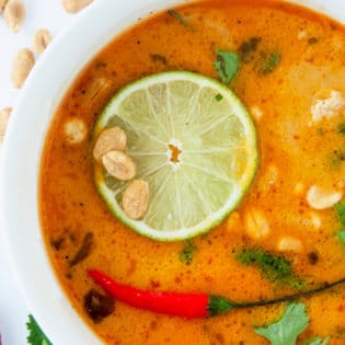 overhead of Thai coconut soup garnished with lime and peppers