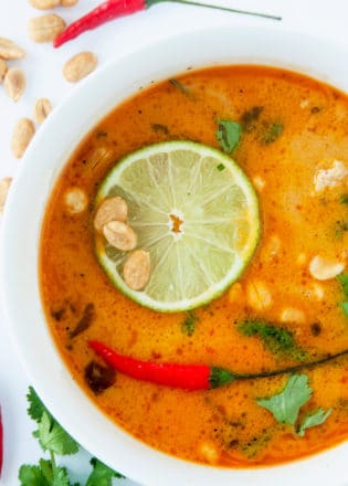 overhead of Thai coconut soup garnished with lime and peppers