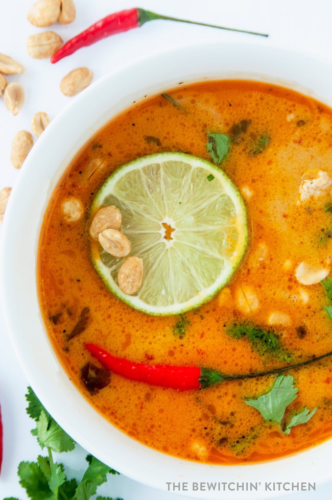 overhead of Thai coconut soup garnished with lime and peppers