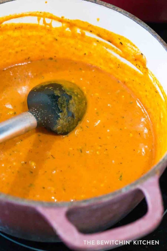 A pot of a healthy butter chicken sauce simmering over the stove.