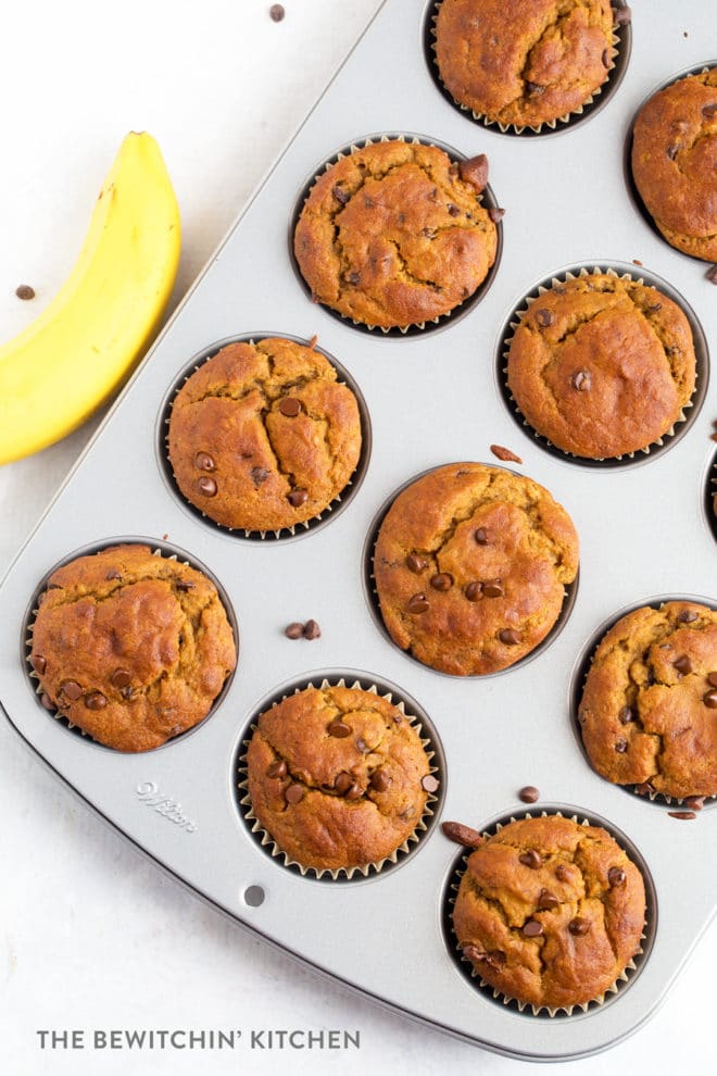 Overhead shot of gluten free muffins in a muffin tin with bananas beside it.