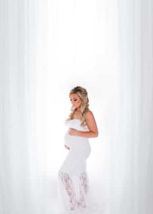 Glam maternity session - pregnant girl standing in a white dress