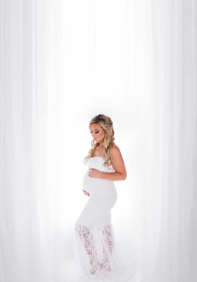 Glam maternity session - pregnant girl standing in a white dress