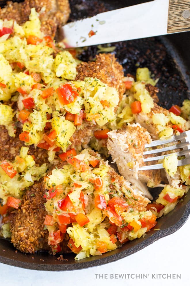 A fork picking up a piece of coconut crusted chicken