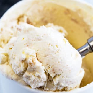 No churn key lime pie ice cream being scooped out of a reusable ice cream container.