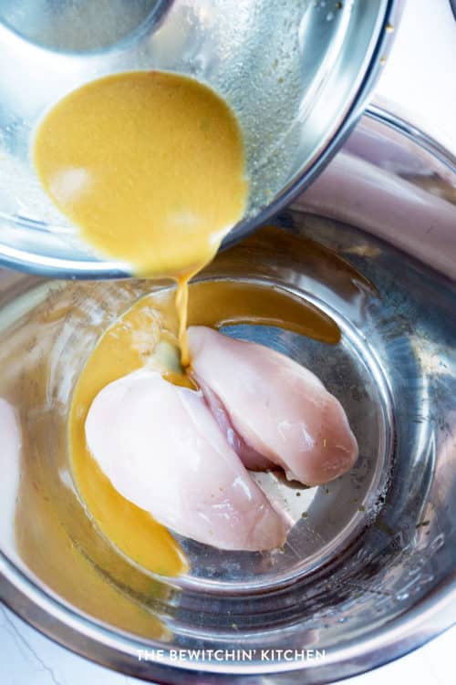 Pouring a ginger lime sauce over chicken breasts in an Instant Pot