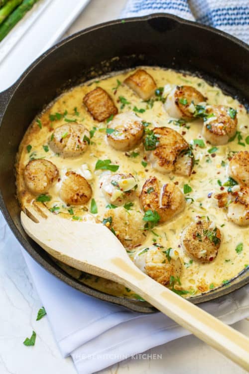 stirring seared scallops in white wine garlic cream sauce